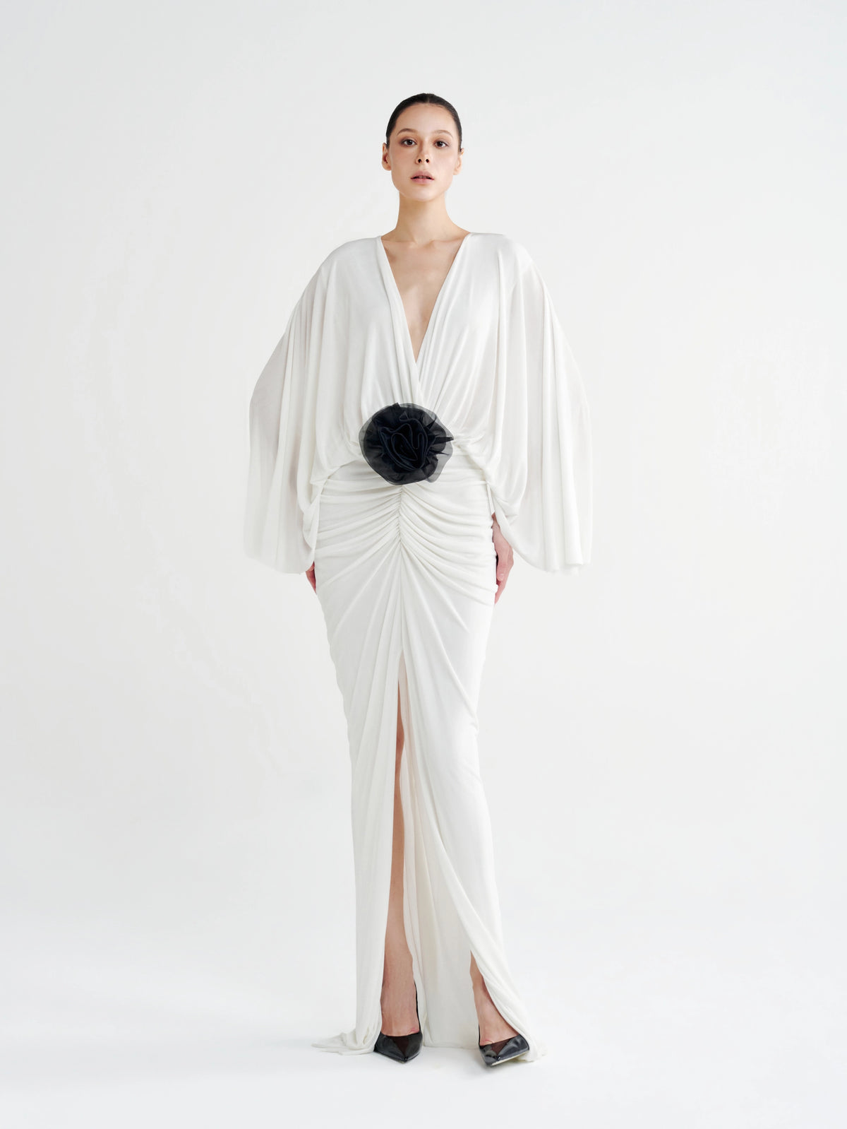 White Rosette Plunging Batwing Ruched Dress with a black rosette at the waist, front view