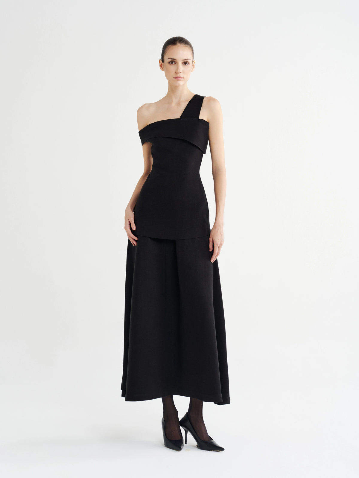 Black Structured Asymmetric Off-Shoulder Top with the black Minimalist Flared Midi Skirt, front view
